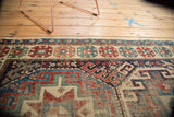 Antique Caucasian runner detail: Moghan Kazak geometric motifs in navy, red, ivory, with pile wear.