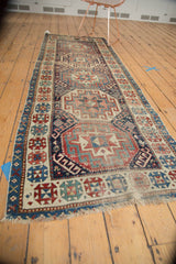 Antique Moghan Kazak runner end, displaying geometric guls in navy, wine, ivory, and mostly even pile wear.