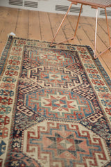 Close-up of antique Moghan Kazak runner's geometric medallions, cloud bands, and gem tones.