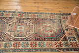 Geometric guls and flowers on an antique Moghan Kazak runner, showcasing gem-like colors and wear.