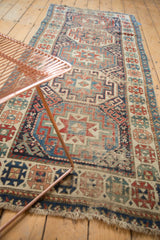 Moghan Kazak geometric patterns in gem-tone blues, reds, ivory, showing knot head wear.