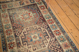 Geometric patterns and intricate border on a Moghan Kazak antique runner with even pile wear.
