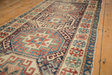 Saturated navy, red, and ivory geometric guls define this antique Moghan Kazak runner's field.