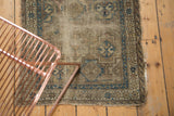 Caucasian Chi Chi rug corner featuring geometric blue starburst border and aged ivory, brown textile.