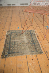 Angled view highlighting the worn pile and tattered ends of this antique Chi Chi mat.
