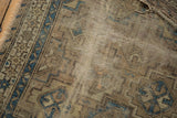 Close-up of antique Chi Chi rug with visible wear, exposed foundation, and tattered edge.