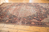 Scalloped pale raspberry medallion meets navy millefleur field and floral main border on this antique Farahan Sarouk rug.