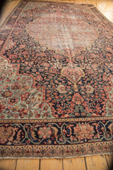 Antique Farahan Sarouk rug: navy blue border with raspberry floral vinery, geometric band, and fringe.