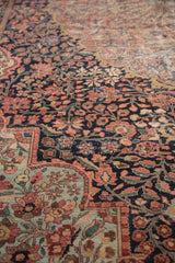 Detail of antique Farahan Sarouk rug showing navy field, pale raspberry vinery, and sea foam green rococo contour.