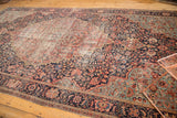Antique Farahan Sarouk rug's intricate vinery, millefleur designs, navy, red, teal, and tattered edge.