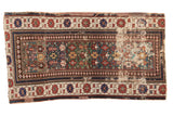 Antique Caucasian rug: unusual green field, geometric motifs, wide borders, visible wear, seam. 2'11