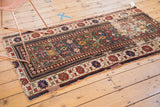 Wide banded border of antique Caucasian rug, with cinnabar red and navy blue geometric motifs.