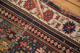 Antique Caucasian rug: detail of seam, historic repairs, teal field, and banded border.