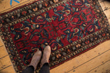 Vintage Lilihan rug with allover arabesque design, raspberry red field, and tattered edges.