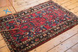 Vintage Lilihan rug corner, dark border frame, red field with blue arabesque flowers, worn edge.