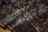 Folded vintage Hamadan rug pile, showcasing rich indigo, bronze, and blush Herati patterns.