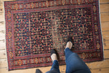 Vintage Senneh rug with allover Herati motif, navy blue and red, showing pile wear.