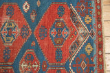 Distinctive design shift, geometric border, and fringed end of the Antique Shirvan rug.