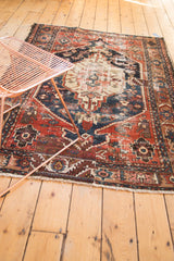 Antique Northwest Persian rug's geometric border, showing a storied patch and exposed foundation.