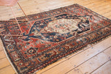 Antique Northwest Persian rug with a worn geometric border showing exposed foundation.
