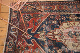 Worn antique Northwest Persian rug detail: geometric field, exposed foundation, and patched color disparity.