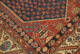 Antique Malayer rug corner: navy boteh field, rust spandrel with potted plant motif.