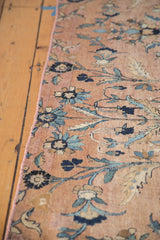 Antique Kerman fragment with hand-bound selvage, beige field, and blue floral vinery.
