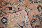 Antique Kerman rug corner with hand-bound pinkish selvage revealing blue floral palmettes.
