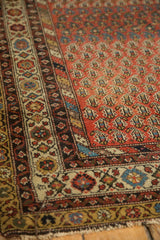 Antique Hamadan rug corner, showing madder red boteh field, detailed borders, and knot head wear.