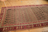 Corner of antique Karabagh carpet, displaying staggered boteh pattern and wine red paisley border.