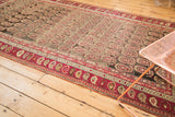 Antique Karabagh carpet border showcasing wine red paisley motifs and repeating muted field botehs.