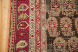 Antique Karabagh rug: deep red boteh border and worn charcoal field pattern.