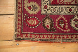 Antique Karabagh rug corner, wine red field, ivory germinating boteh motifs, geometric border.