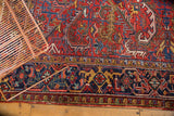 Traditional Heriz rug border in navy blue, highlighting the worn cherry red field.
