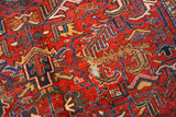 Heriz carpet detail showing dramatic serrated leaves, cherry red field, and areas of threadbare foundation.