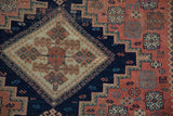 Detail of antique Afshar rug showing stepped medallion and geometric motifs in indigo, dusty blush, ivory.