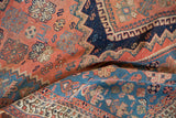 Antique Afshar rug detail with folded, soft wool pile revealing floral and stepped patterns.