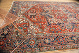 Vintage Heriz carpet's corner with red and blue geometric motifs and polychrome selvage.
