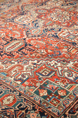 Vintage Heriz rug's geometric serrated palmettes in cherry red, navy, and teal.