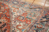Vintage Heriz carpet's serrated palmette designs and borders in cherry red, navy, green.