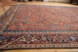 Navy main border with samovar design, floral minor borders, and brick red Heriz field.