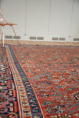 Persian Heriz rug's geometric field and classic samovar border in brick red and navy.