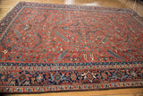 Traditional Persian Heriz carpet's navy samovar border and brick red field of serrated leaves.