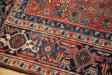 Heriz carpet detail: classic main border samovar pattern in brick red, navy, and ivory.