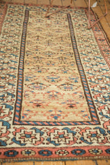 Kurdish rug corner displaying madder root red, sky blue, and ivory geometric border patterns.