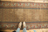 Antique Kurdish runner, its pale gold field with wear, minor latch border, and tattered end.