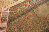 Antique Kurdish rug field with visible wear, exposed foundation, and a primitive patch.