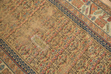 Antique Kurdish runner's worn gold field, red and blue plant motifs, and primitive patch.
