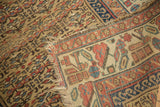 Tattered edge, antique Kurdish rug, golden geometric field, and ivory patterned border.