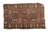 Antique Caucasian Avar rug with geometric medallions, red, brown, teal, and extensive tattered wear.
